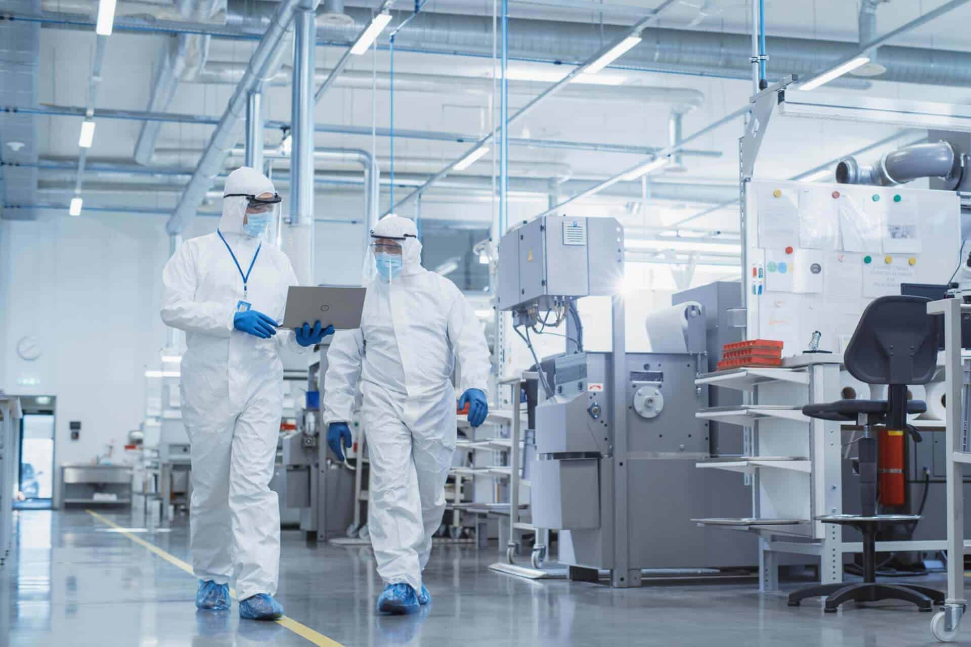 Two researchers in cleanroom suits
